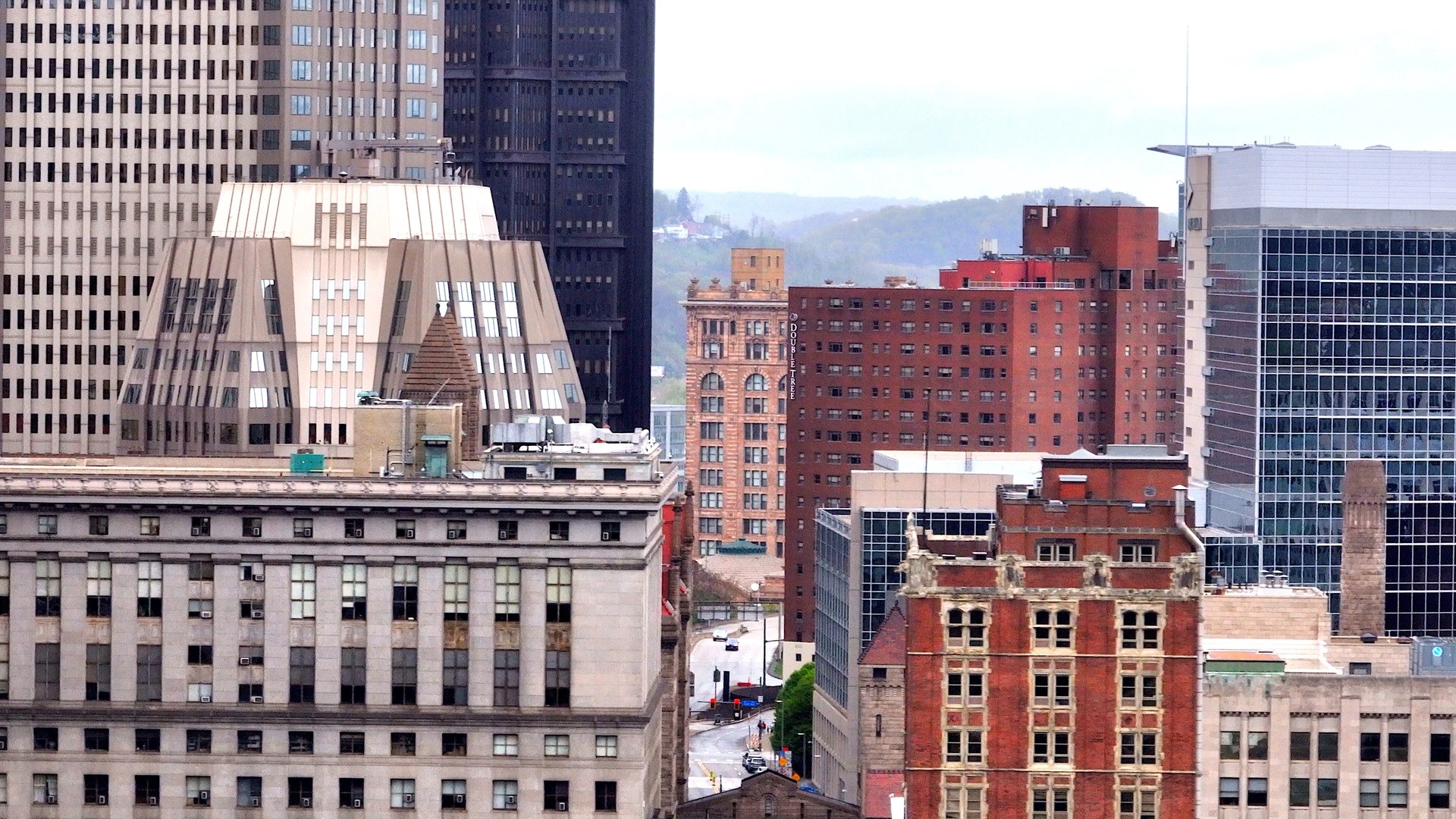Pittsburg, PA city skyline with office buildings, bridges, highways downtown beside river